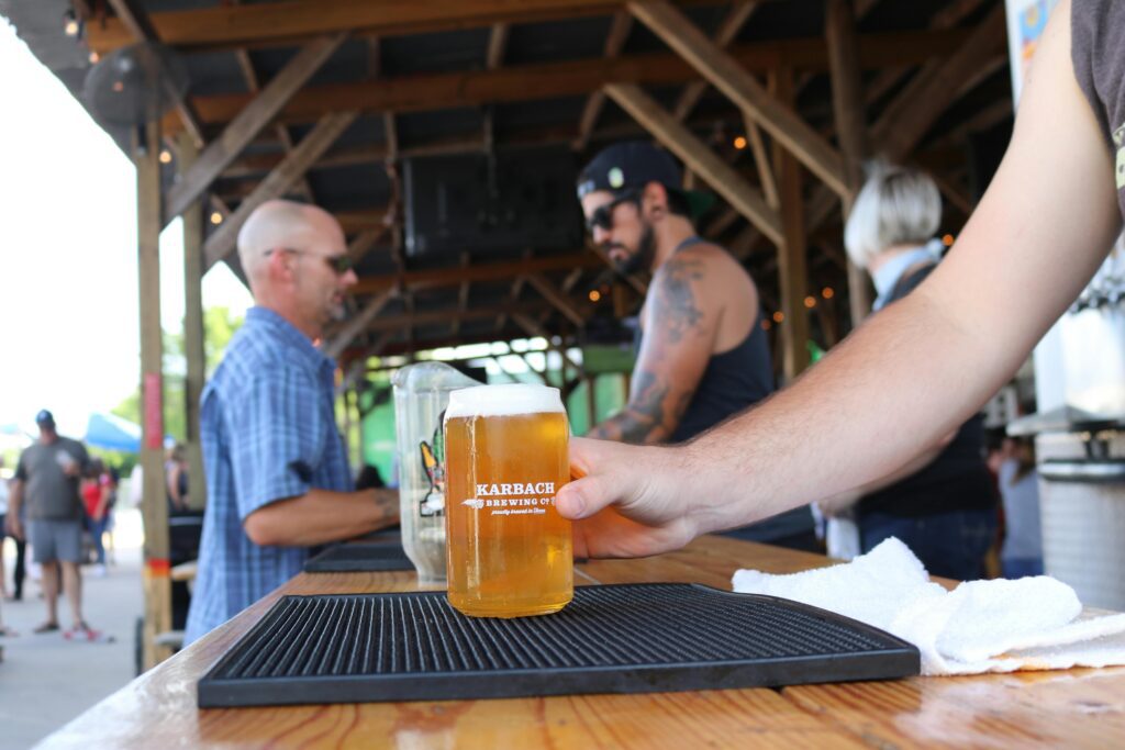 Man holding a pint of beer in an indoor brewery setting