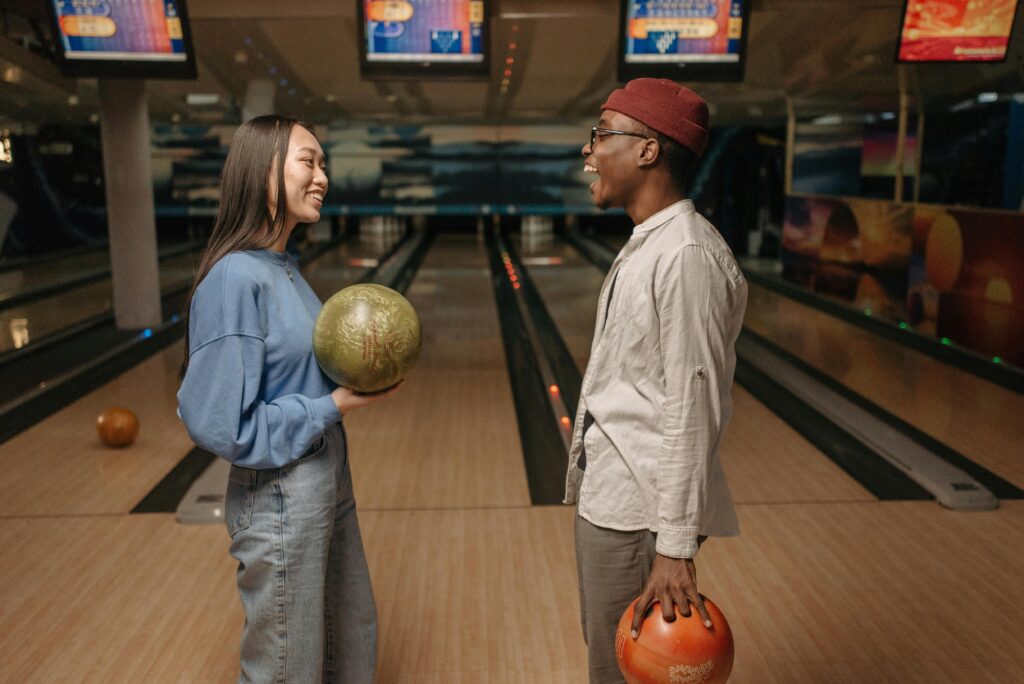 girl and boy playing bowling. indoor date idea Calgary 